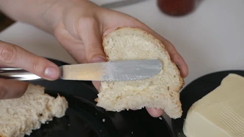 Spreading butter on a fresh slice of rye bread with a knife. Easy and quick 스톡 동영상 135474443