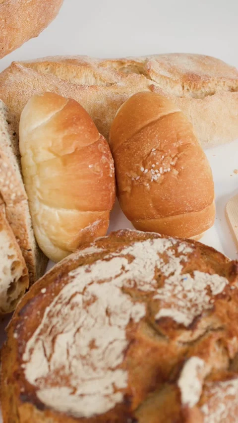 Spreading Butter on Fresh Sliced Bread with Bakery Assortment Stock Footage 337747189