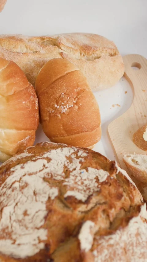 Spreading Butter on Fresh Sourdough Bread in Artisan Bakery Setting Video stock 337769067