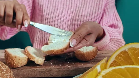 Spreading Butter on a Slice of Sesame Bread During Breakfast Preparation 库存影片 331099017