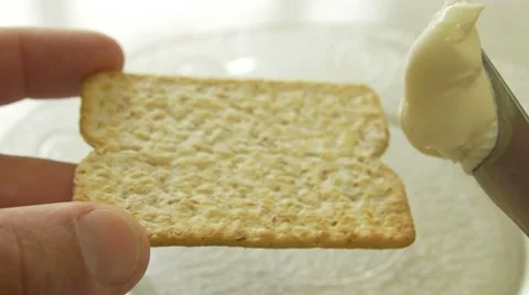 Spreading cheese on a whole wheat cracker 4K Video stock 42480921