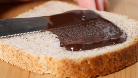 Spreading chocolate on bread Stock Footage 100304839