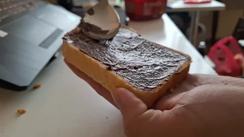 Spreading Chocolate Cream on White Bread Slice Stock Footage 329748706