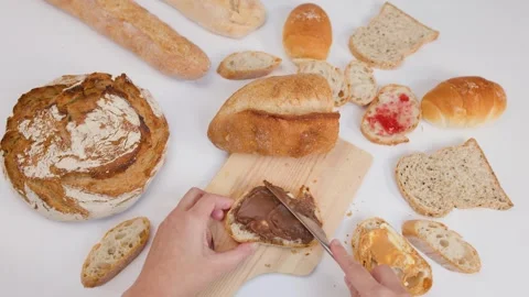 Spreading Chocolate Hazelnut Cream on Fresh Sourdough Bread Slice Stock Footage 337533054