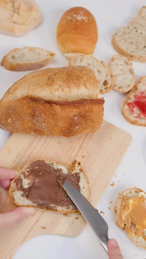 Spreading Chocolate Hazelnut Cream on Fresh Bread Slice Stock Footage 337533147