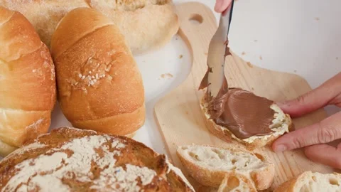 Spreading Chocolate Hazelnut Cream on Fresh Bread for Breakfast Stock Footage 337535311
