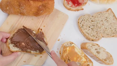Spreading Chocolate Hazelnut Cream on Fresh Sourdough Bread Slice Stock Footage 337535314
