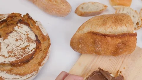 Spreading Chocolate Hazelnut Cream on Fresh Sourdough Bread Slice Stock Footage 337535515