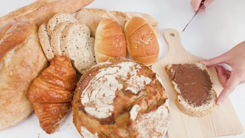 Spreading Chocolate Hazelnut Cream on Fresh Whole Wheat Bread Slice Stock Footage 337917835