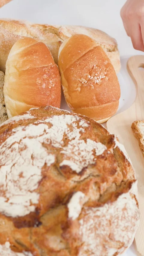 Spreading Chocolate Hazelnut Cream on Fresh Bread with Bakery Assortment Stock Footage 337925943