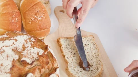 Spreading Chocolate Hazelnut Cream on Fresh Sourdough Bread Slice Stock Footage 337995236