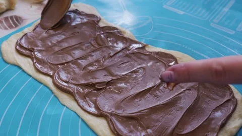 Spreading Chocolate Hazelnut Cream Over Fresh Sweet Pastry Dough Видео 334119445