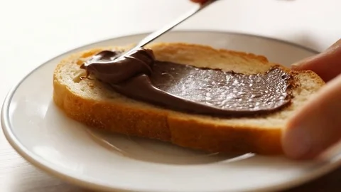 Spreading chocolate pasta on bread Stock Footage 81249577