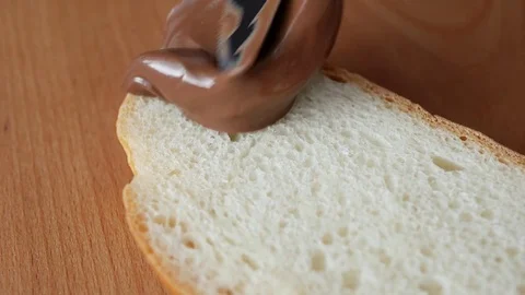 Spreading chocolate paste on white bread. Stock Footage 72175264