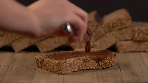Spreading Chocolate Spread on a Loaf Of Bread 스톡 동영상 130536479
