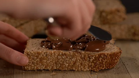 Spreading Chocolate Spread on Multi Grain Slice Of Bread Video stock 130132163