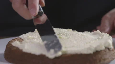 Spreading cream on a cake Stock Footage 64055098