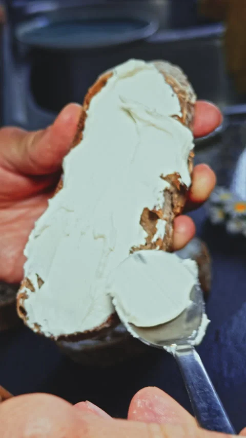 Spreading cream cheese on bread Stock Footage 277727459