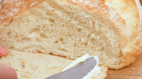 Spreading cream cheese on brioche bread. Video stock 74074926