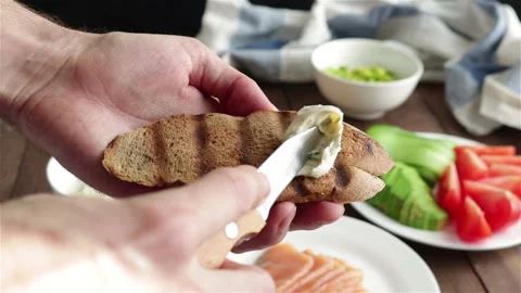 Spreading cream cheese on grilled bread making sandwich Stock Footage 123906351