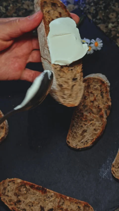 Spreading Cream Cheese on Toasted Multigrain Bread Stock Footage 277725304