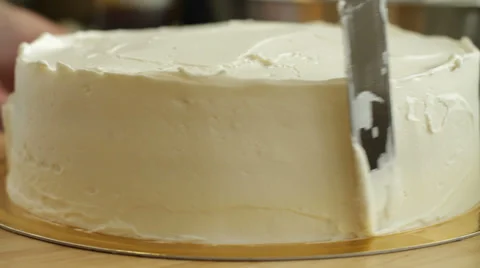 Spreading cream while the cake spins Stock Footage 32358912
