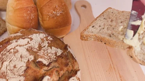 Spreading Creamy Peanut Butter on Multigrain Bread Slice Stock Footage 337521183