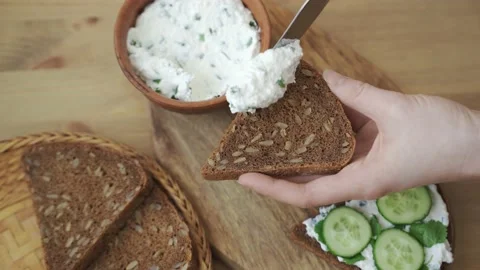 Spreading curd cheese on a piece of bread. Stock Footage 149911368