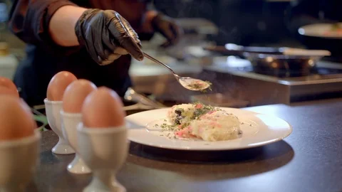Spreading fresh spices on omelette for breakfast menu in restaurant Stock Footage 99577310