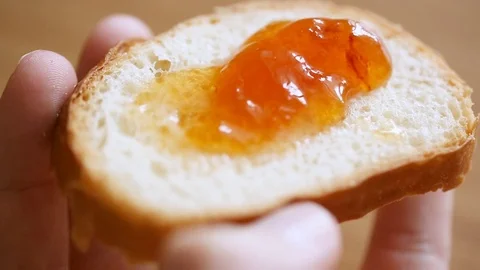 Spreading fruit jam on bread slice Stock Footage 81329971