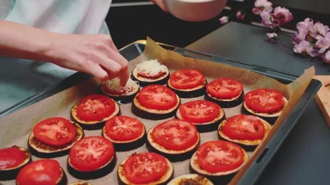Spreading grated cheese on tomatoes with eggplant Stock-Footage 252180683