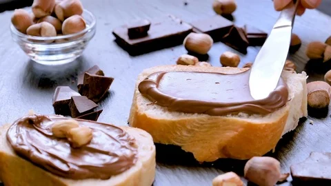 Spreading hazelnut chocolate cream on bread closeup Video stock 81179724