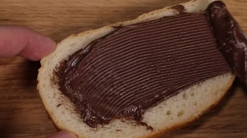 Spreading hazelnut chocolate spread on toasted bread Stock Footage 230178816