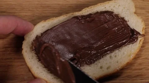 Spreading hazelnut chocolate spread on toasted bread Stock Footage 230178945