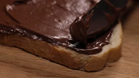 Spreading hazelnut chocolate spread on toasted bread Stock Footage 230180683