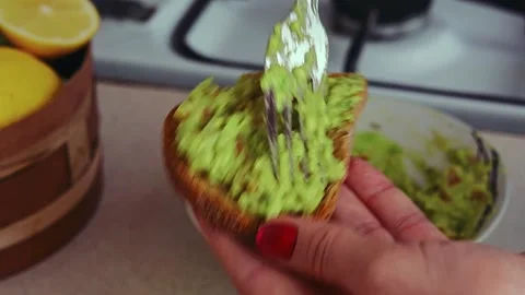 Spreading mashed avocado on rye bread. Stock Footage 171812106
