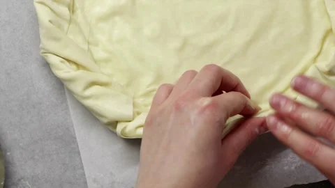 Spreading melted butter on raw pastry base using pastry brush Stock Footage 336848403