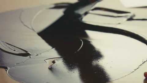 Spreading melted dark chocolate on a surface with spatula Stock Footage 274636700