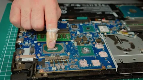 Spreading new thermal paste on laptop processor surface evenly. Ensuring proper Stock Footage 303154029