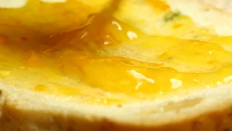 Spreading  orange jam on bread Stock Footage 91297239
