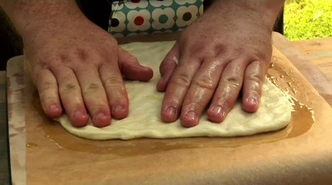 Spreading out pizza dough on baking parchment Stock Footage 8572445