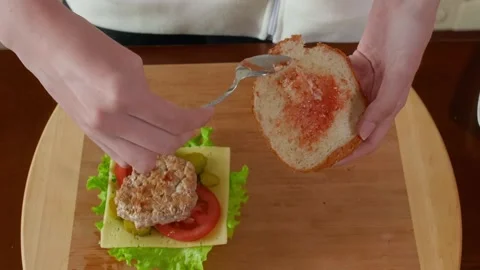 Spreading pate on bread slice while assembling sandwich on wooden board 库存影片 345061186