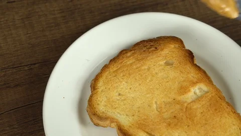 Spreading peanut butter on baked bread Stock Footage 113074217