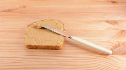 Spreading peanut butter onto a slice of bread Stock Photos