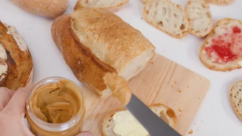 Spreading Peanut Butter on Sourdough Bread for Breakfast Preparation Stock Footage 337226274