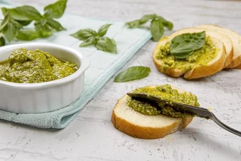 Spreading pesto on bread. Stock Photos