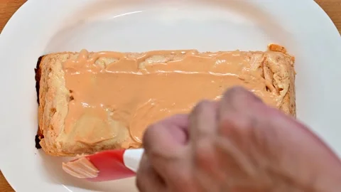 Spreading pink sauce on pudding Stock Footage 228222251