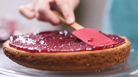 Spreading raspberry jam on Victoria Sponge cake. Stock Footage 151042180