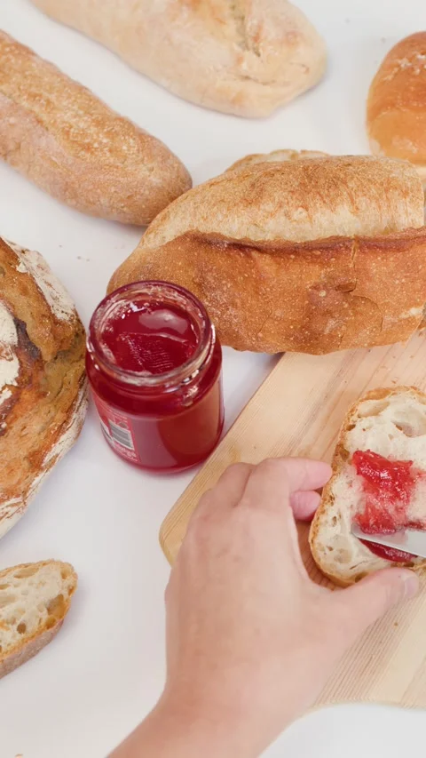 Spreading Red Strawberry Jam on Fresh Sourdough Bread Slice Stock Footage 337690914