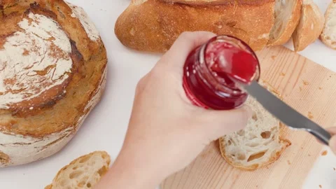 Spreading Red Strawberry Jam on Sourdough Bread Slice Stock Footage 337746713